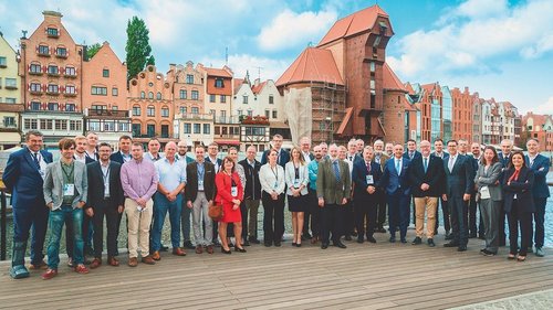 Delegacje europejskich organizacji członkowskich na tle historycznej zabudowy Gdańska.